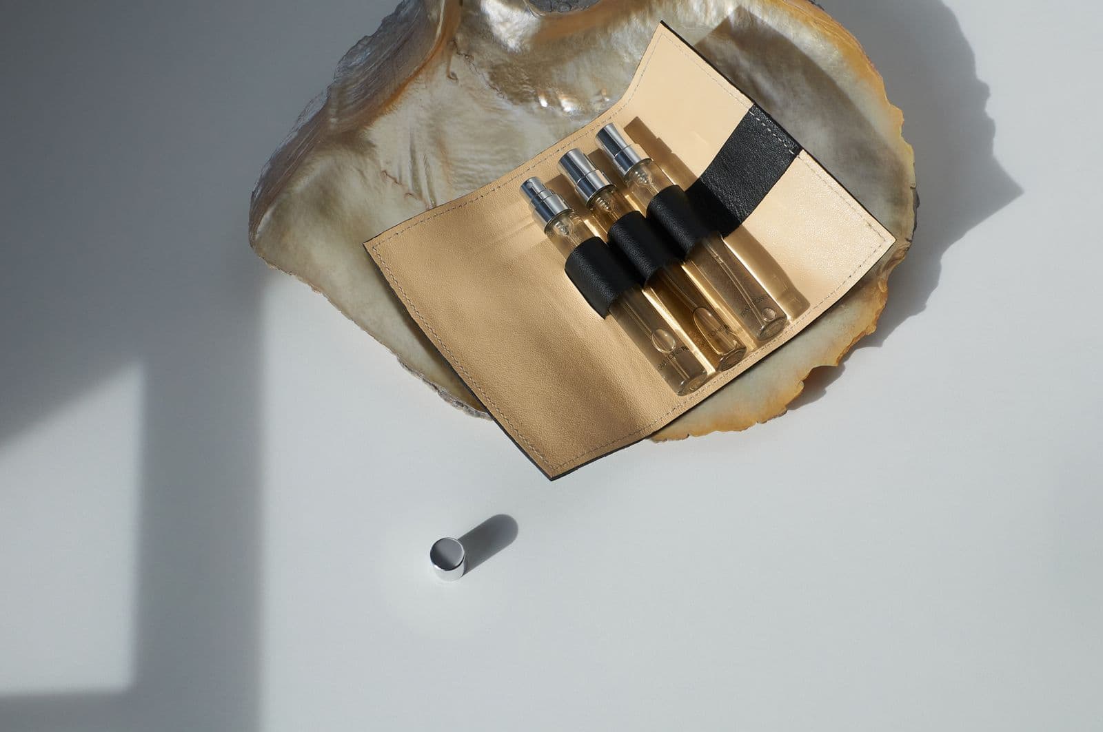Decants de perfume con atomizador en un estuche de cuero